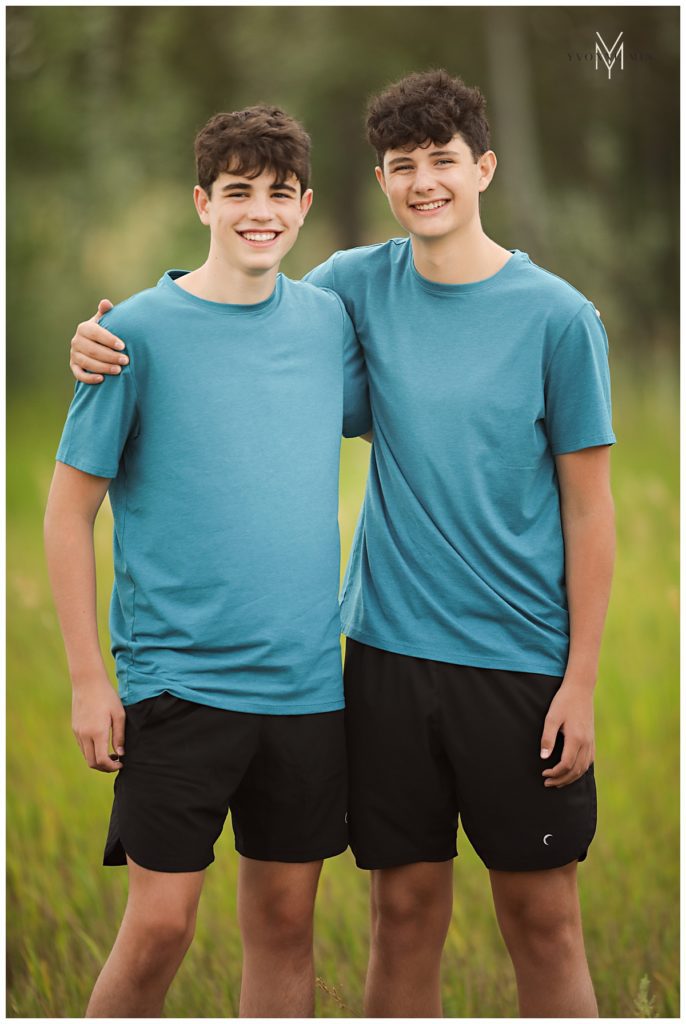 Broomfield high school senior standing with his brother in matching blue shirts.