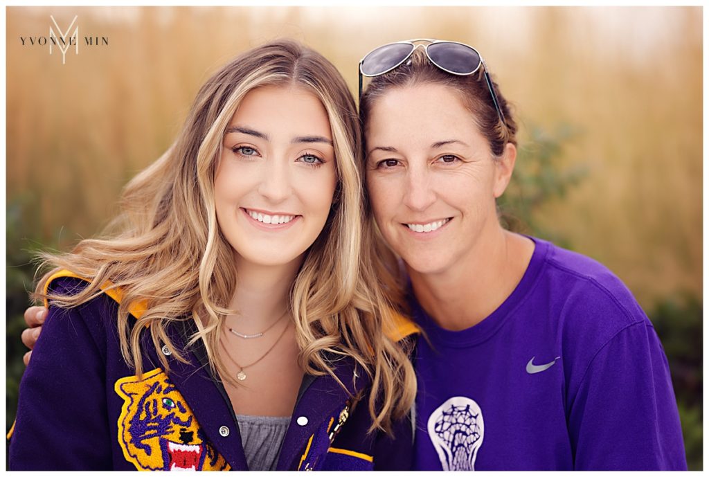 High school senior girl and her mom posting together in a field.
