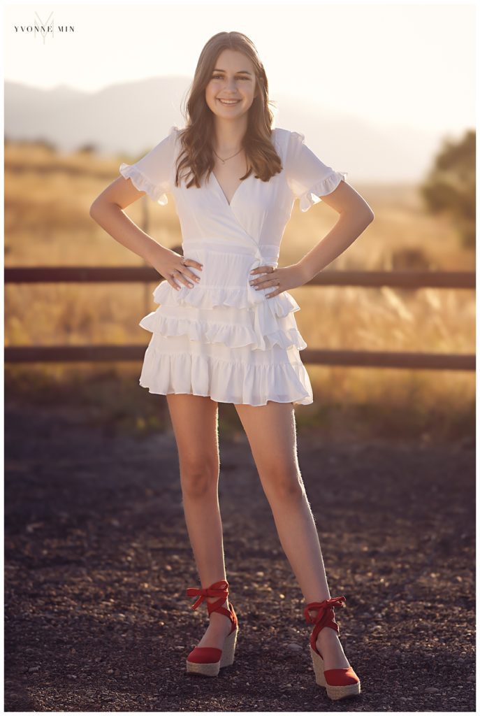 High school senior girl in a white dress at Oerman Rosch trailhead in Superior, Colorado with Yvonne Min.
