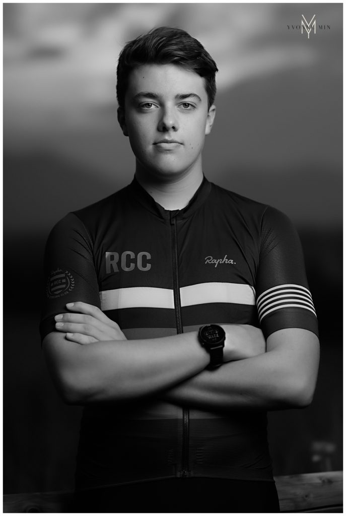 Black and white image of a high school senior boy in his mountain bike racing gear.