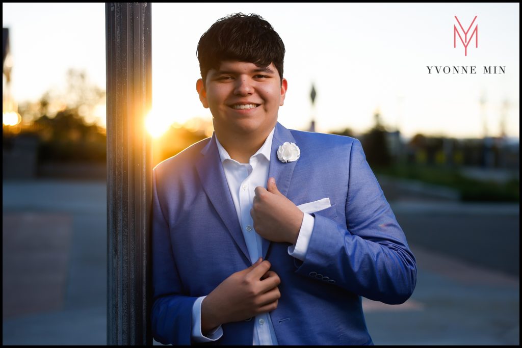 Luis leans against a light post for a senior photograph in Old Town East Lake in Thornton, Colorado.