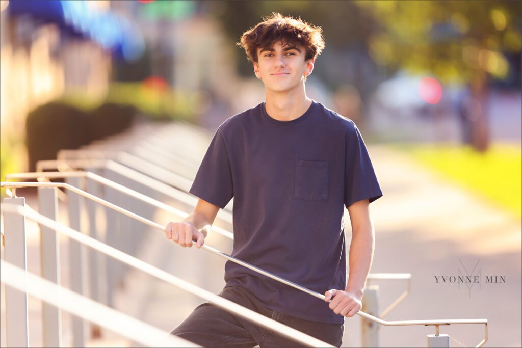 A senior in high school from Erie, Colorado poses against a guard rail in LoDo Denver during his senior shoot.