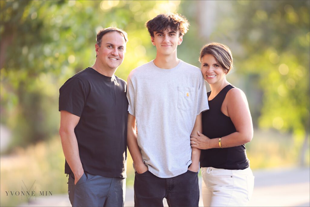 A mom and dad pose with their high school senior boy during this senior photoshoot in downtown Denver.