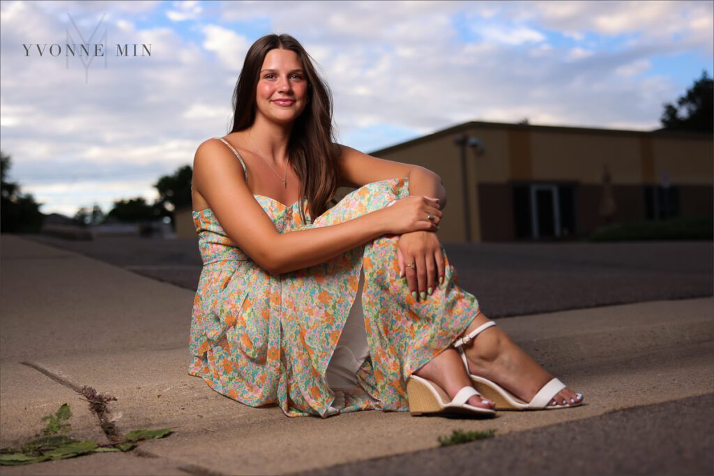 A high school senior picture of a girl in a floral dress with with off-camera flash in Golden, Colorado.