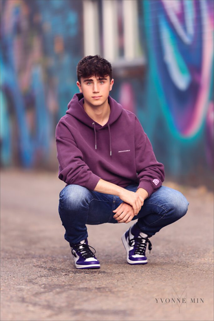 A high school senior basketball player from Stargate High School poses for his senior photos in RiNo Art District, Denver with Yvonne Min Photography.