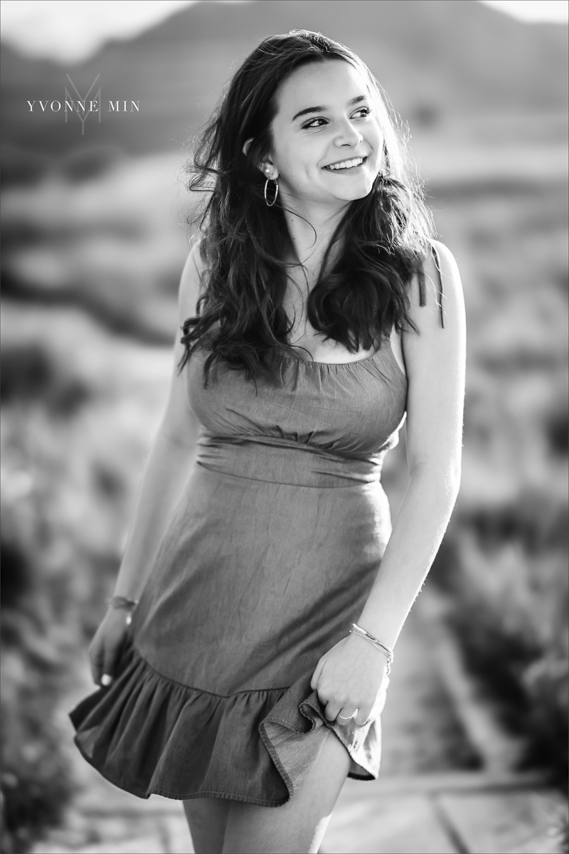 A black and white senior picture of a Stargate High School girl posing in a dress at her senior photoshoot at Flatirons Vista outside Boulder, Colorado with Yvonne Min Photography.