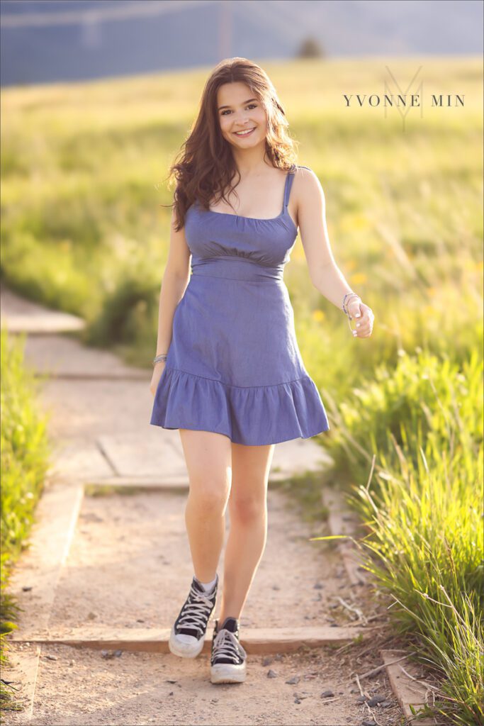 A senior picture of a Stargate High School girl walking on a path at Flatirons Vista taken near Boulder, Colorado by Yvonne Min Photography.