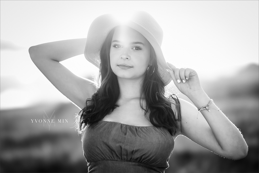 A black and white senior picture of a Stargate High School girl posing in a hat at her senior photoshoot at Flatirons Vista outside Boulder, Colorado with Yvonne Min Photography.