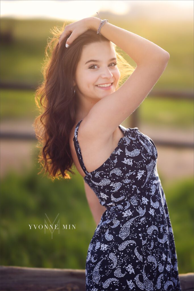 A  senior picture of a Stargate High School girl posing in a dress at her senior photoshoot at Flatirons Vista outside Boulder, Colorado with Yvonne Min Photography.