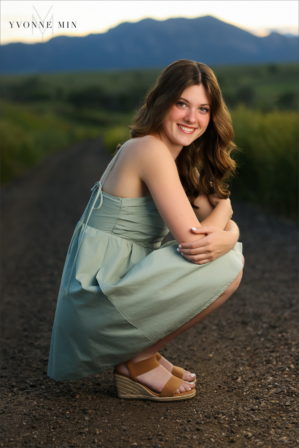 A Stargate High School senior girl poses in front of the sunset at her senior photoshoot with Yvonne Min Photography at Purple Park in Superior, Colorado.