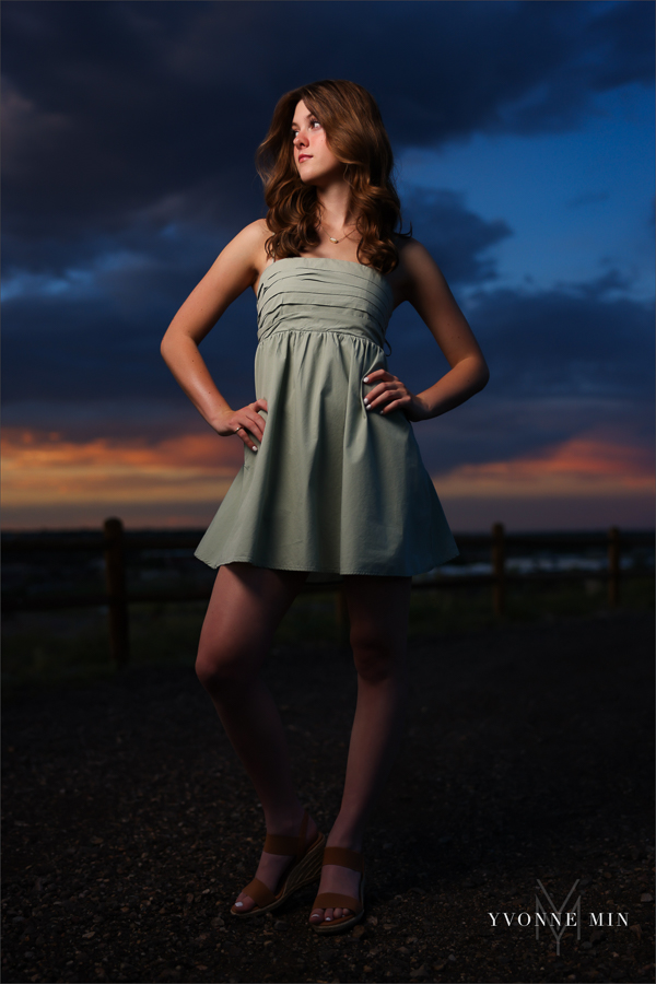 A Stargate High School senior girl poses in front of the sunset at her senior photoshoot with Yvonne Min Photography at Purple Park in Superior, Colorado.