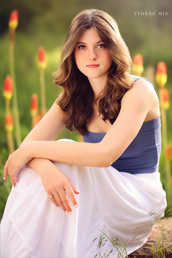 A senior picture of a Stargate High School girl taken at sunset with flowers  in Purple Park, Superior, Colorado by Yvonne Min Photography.