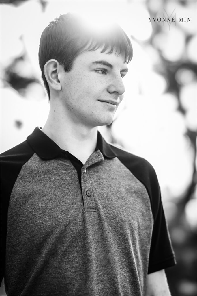 A black & white senior picture of a Stargate High School senior boy in a gray t-shirt taken in the mountains above Boulder, Colorado by Yvonne Min Photography.