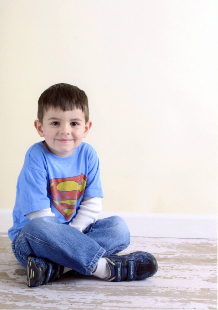 A preschool photo of the same Stargate High School student wearing a similar superman t-shirt taken by Yvonne Min Photography at the Goddard Preschool in Thornton, CO.