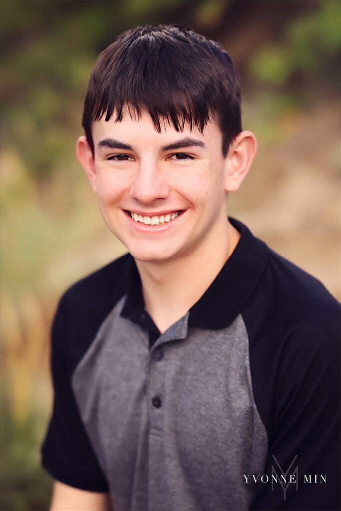 A headshot senior portraits of a Stargate High School student in a gray shirt at Chautauqua Park in Boulder, Colorado by Yvonne Min Photography.