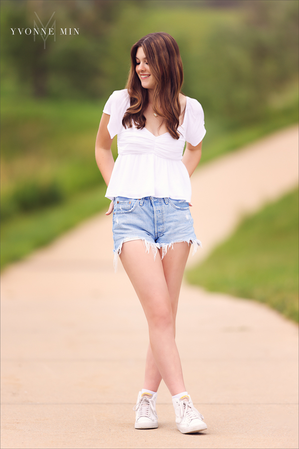 A Stargate High School senior girl poses for her senior pictures photoshoot in the grassy area of Purple Park, Superior, Colorado taken by Yvonne Min Photography.