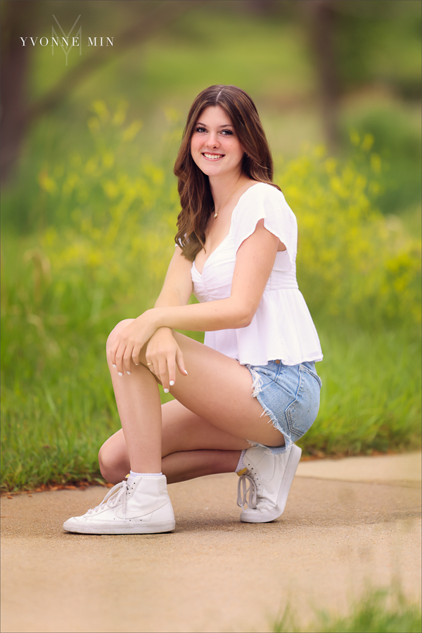 A Stargate High School senior girl poses for her senior pictures photoshoot in the grassy area of Purple Park, Superior, Colorado taken by Yvonne Min Photography.