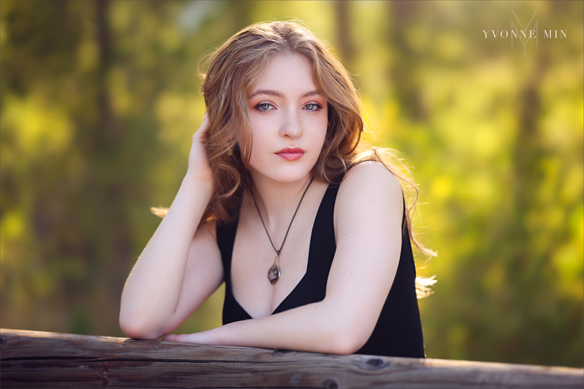 High school senior picture of a Stargate student leaning on a fence taken by Yvonne Min Photography at South Mesa Trailhead.