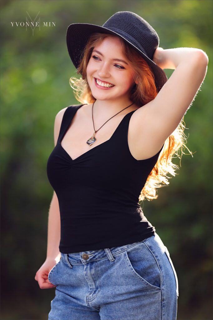 A high school senior girl from Stargate High School poses in a black hat at her senior photoshoot session with Yvonne Min Photography at South Mesa Trailhead.