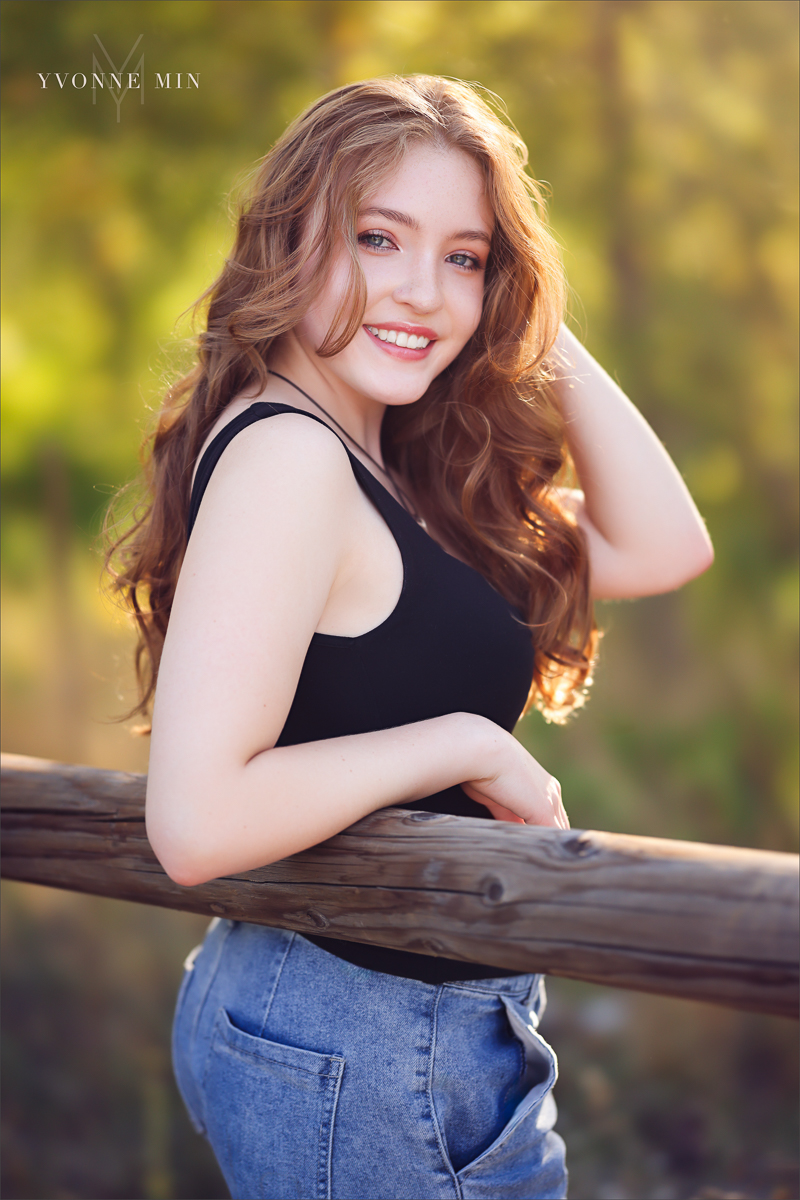 High school senior picture of a Stargate student leaning on a fence taken by Yvonne Min Photography at South Mesa Trailhead.