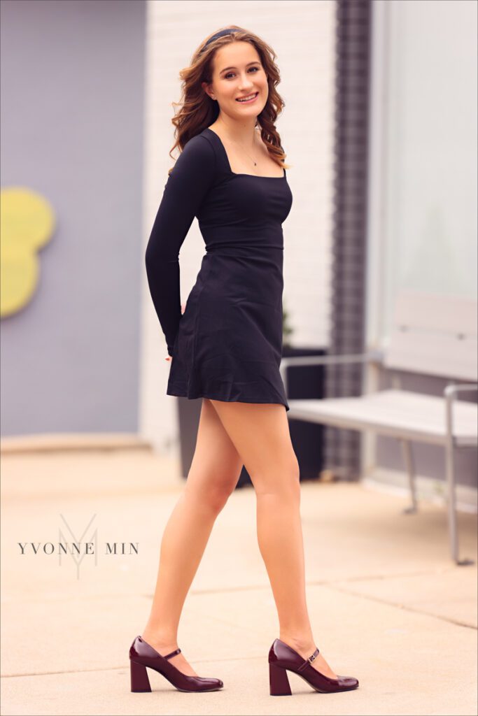 A senior photo of a student from Legacy High School posing in a black dress with Yvonne Min Photography at her photoshoot in downtown Louisville, Colorado.