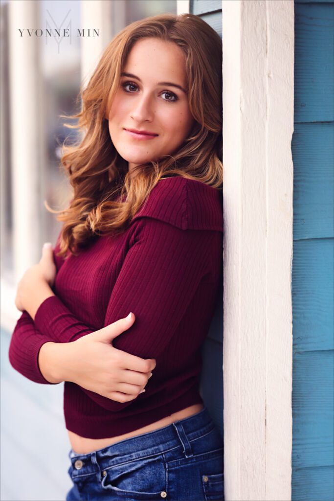 A high school senior picture of a student from Legacy High School posing against a wall in downtown Louisville, Colorado with Yvonne Min Photography.