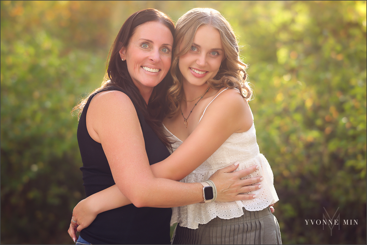 A high school senior girl from Jefferson Academy poses with her mom at her senior photoshoot at South Mesa Trailhead outside Boulder with Yvonne Min Photography.