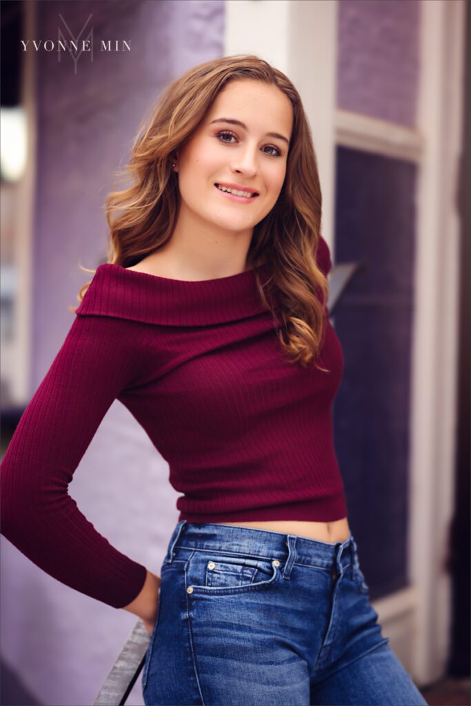 A high school senior picture of a student from Legacy High School posing against a wall in downtown Louisville, Colorado with Yvonne Min Photography.