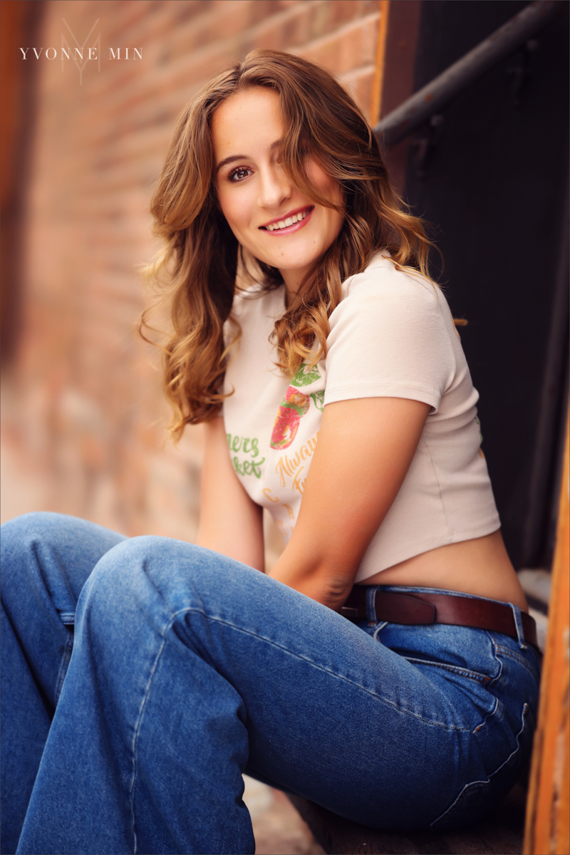 A high school senior picture of a student from Legacy High School posing in downtown Louisville, Colorado with Yvonne Min Photography.