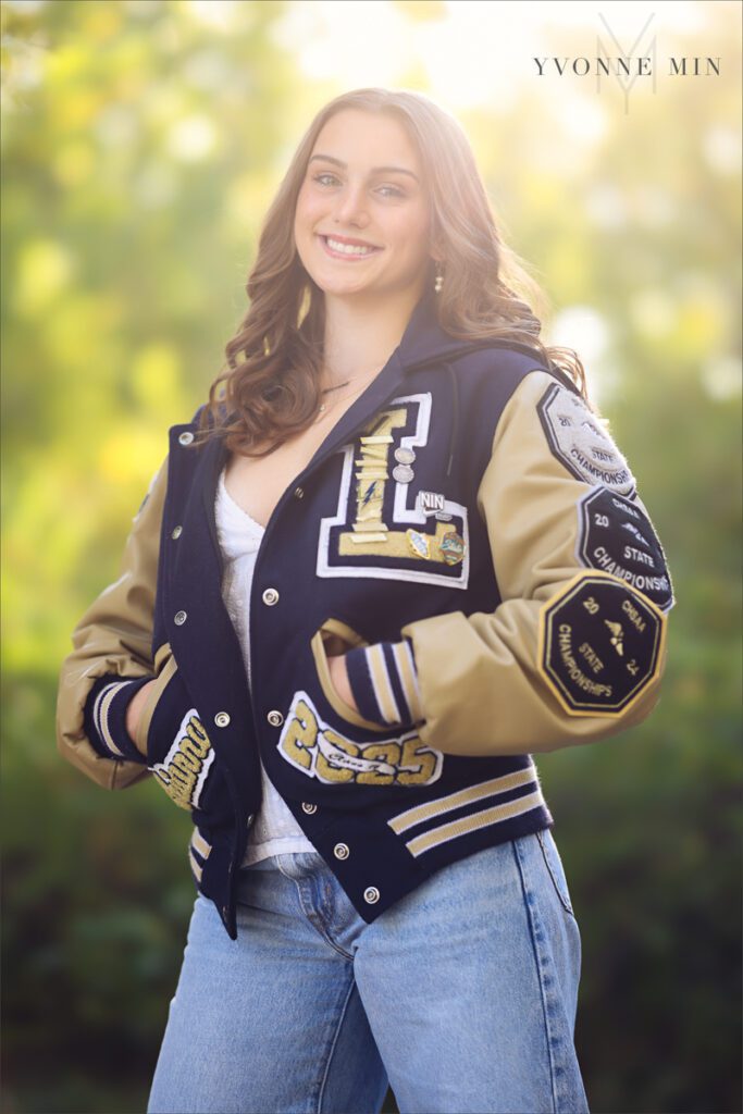 A high school senior picture of a girl from Legacy High School in her letter jacket  taken by Yvonne Min Photography at South Mesa Trailhead outside Boulder.